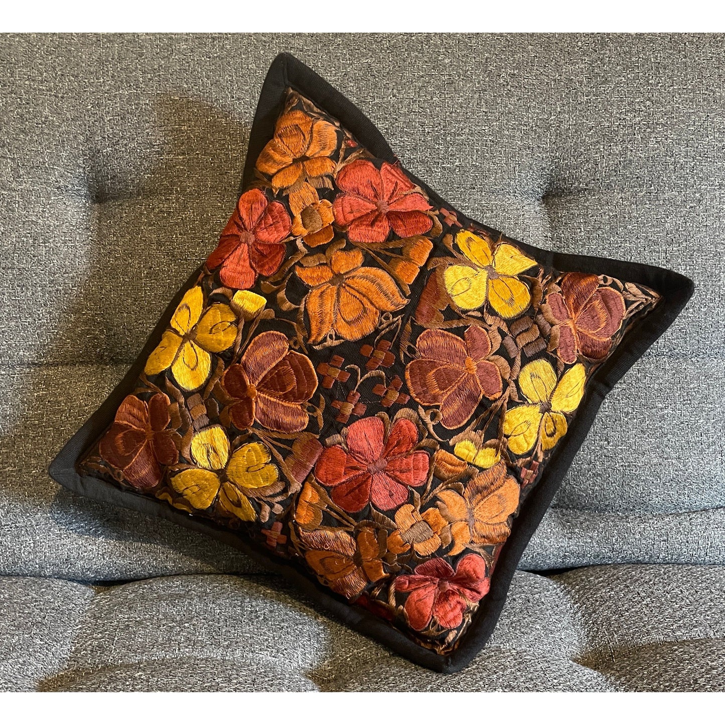 Handbestickter Kissenbezug aus Oaxaca – Schwarzer Stoff mit farbenfrohen Blumenmustern, traditionell handgefertigt in Mexiko.